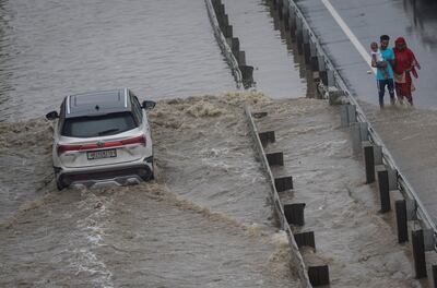 A family walks past a flooded street as a car drives past after heavy rains in Gurugram, on the outskirts of New Delhi, India, September 23, 2022. REUTERS / Adnan Abidi