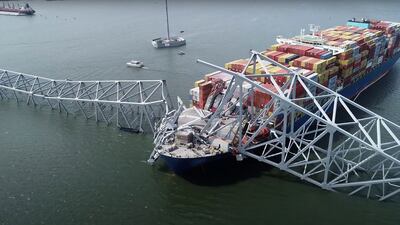 A handout screengrab shows part of the steel frame of the Francis Scott Key Bridge sitting on top of the container ship Dali after the bridge collapsed in Baltimore, Maryland. AFP