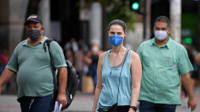BELO HORIZONTE, BRAZIL - JANUARY 18: People walk wearing facemasks through downtown on January 18, 2022 in Belo Horizonte, Brazil. The omicron variant has caused a spike in COVID-19 infections in Brazil with an average of 75,000 new daily cases. (Photo by Pedro Vilela / Getty Images)