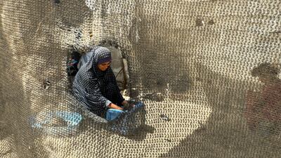 A displaced Palestinian woman, who fled her house due to Israel's military offensive, washes clothes at a tent camp, amid the ongoing conflict between Israel and Palestinian Islamist group Hamas, in Rafah, in the southern Gaza Strip May 23, 2024. REUTERS/Mohammed Salem