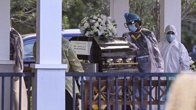 Workers carry the coffin of Sri Lanka's former foreign minister Mangala Samaraweera, who died today due to the Covid-19 coronavirus, before the cremation at Colombo's main cemetery on August 24, 2021. (Photo by ISHARA S. KODIKARA / AFP)