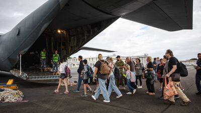 Tourists board an Australian military plane as part of an evacuation process in Noumea, New Caledonia, where rioting has spread. AP