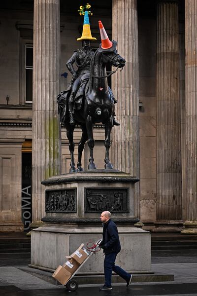 GLASGOW, SCOTLAND - MARCH 07: The Duke of Wellington Statue wears a traffic cone with a knitted cover in the colours of the Ukraine flag on March 07, 2022 in Glasgow, Scotland. Russia invaded neighbouring Ukraine on 24th February 2022, its actions have met with worldwide condemnation with rallies, protests, peace marches and acts of solidarity taking place in cities across the globe. (Photo by Jeff J Mitchell / Getty Images)