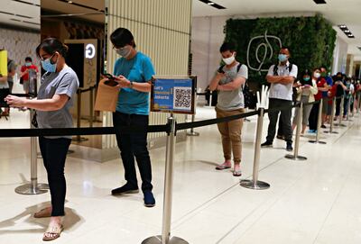 People wearing face masks wait to be scanned to enter a mall in Abu Dhabi. REUTERS / Ajeng Dinar Ulfiana