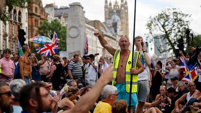 Demonstrators stage a sit-down protest outside Downing Street against government lockdown restrictions, 5G and Covid-19 vaccinations in central London. Britain has delayed the full lifting of coronavirus restrictions in England owing to a surge of infections caused by the Delta variant. AFP
