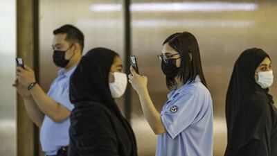 Safety stewards scan shoppers with smartphones enabled with Covid-19 detection software, developed by EDE Research Institute, at the entrance of Yas Mall, operated by Aldar Properties PJSC, in Abu Dhabi, United Arab Emirates, on Thursday, July 1, 2021. Abu Dhabi will use facial scanners - with technology which measures electromagnetic waves which change when RNA virus particles are present - to detect coronavirus infections at malls and airports, after a trial of 20,000 people showed "a high degree of effectiveness." Photographer: Christopher Pike/Bloomberg