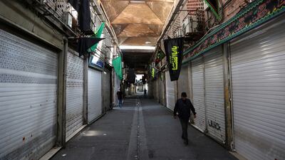 FILE PHOTO: A man walks past closed shops in the Tehran Bazaar following the tightening of restrictions to curb the surge of COVID-19 cases, in Tehran, Iran, August 16, 2021. Majid Asgaripour / WANA (West Asia News Agency) via REUTERS / File Photo