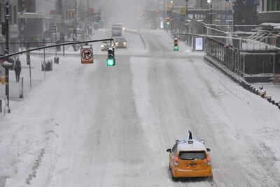 A yellow cab taxi drives through deserted streets in New York City on February 1, 2021. AFP