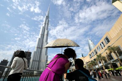 Visitors to Dubai mall take pictures of the Burj Khalifa. Chris Whiteoak / The National