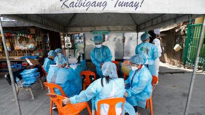 Health workers wearing protective suits prepare to carry out community Covid-19 testing in Manila, capital of the Philippines. EPA