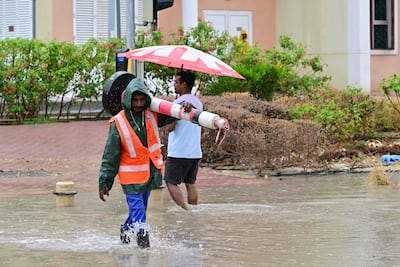 A municipal worker walks along a flooded street in Dubai on May 2, 2024, as heavy rains returned to the United Arab Emirates just two weeks after record downpours that experts linked to climate change. (Photo by Giuseppe CACACE / AFP)
