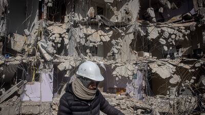 HATAY, TURKEY - FEBRUARY 15: A man walks in front of a destroyed building on February 15, 2023 in Hatay, Turkey. A 7.8-magnitude earthquake hit near Gaziantep, Turkey, in the early hours of February 6, followed by another 7.5-magnitude tremor just after midday. The quakes caused widespread destruction in southern Turkey and northern Syria and has killed more than 30,000 people. (Photo by Chris McGrath / Getty Images)