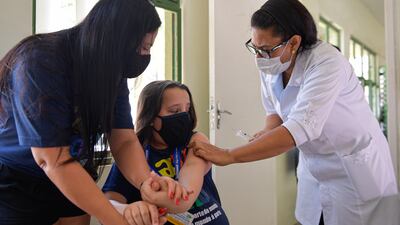 BELO HORIZONTE, BRAZIL - JANUARY 18: Matheus Goncalves Castro receives a dose of Pfizer vaccine as part of the COVID-19 immunization campaign on January 18, 2022 in Belo Horizonte, Brazil. As COVID-19 cases spike due to the Omicron variant in the last week, state governments have decided to start vaccinating children between the ages of 5 and 11. (Photo by Pedro Vilela / Getty Images)