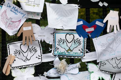 FILE - In this May 28, 2020, file photo, Tributes to lost love ones adorn a fence outside Brooklyn's Green-Wood Cemetery where many victims of COVID-19 are buried in New York. The U. S. death toll from COVID-19 has topped 600,000, even as the vaccination drive has drastically slashed daily cases and deaths and allowed the country to emerge from the gloom. (AP Photo / Mark Lennihan, File)