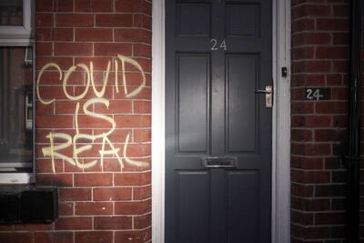 Graffiti declaring 'COVID IS REAL' is spray painted on the wall of a home in Leeds, United Kingdom. Getty Images