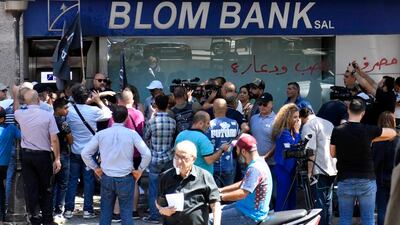 People gather near a Blom Bank branch during an hostage-taking situation in Beirut. EPA