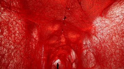 A woman stands inside the art piece 'The network', by the Japanese artist Chiharu Shiota (Gallery Templon), exhibited in the Museum of Tapestries, in Aix-en-Provence, France, May 17, 2024. REUTERS / Manon Cruz