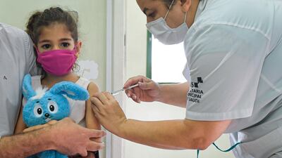 BELO HORIZONTE, BRAZIL - JANUARY 18: A child under 12 years old receives a dose of Pfizer vaccine as part of the COVID-19 immunization campaign on January 18, 2022 in Belo Horizonte, Brazil. As COVID-19 cases spike due to the Omicron variant in the last week, state governments have decided to start vaccinating children between the ages of 5 and 11. (Photo by Pedro Vilela / Getty Images)