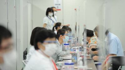 Medical workers consult with people at the mass vaccination center in Tokyo, Japan. Getty Images
