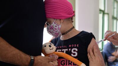 BELO HORIZONTE, BRAZIL - JANUARY 18: A child under 12 years old receives a dose of Pfizer vaccine as part of the COVID-19 immunization campaign on January 18, 2022 in Belo Horizonte, Brazil. As COVID-19 cases spike due to the Omicron variant in the last week, state governments have decided to start vaccinating children between the ages of 5 and 11. (Photo by Pedro Vilela / Getty Images)