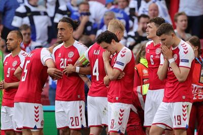Denmark's players gather as paramedics attend to midfielder Christian Eriksen during the Euro 2020 match against Finland. AFP