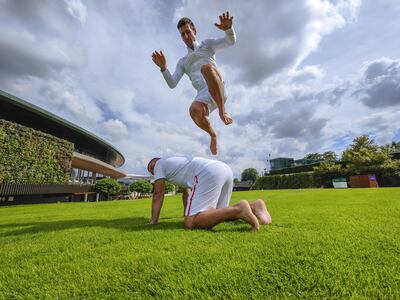 Novak Djokovic jumps over his physiotherapist Ulises Badio after a practice session at The All England Lawn Tennis and Croquet Club. PA
