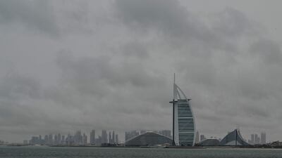 Thick clouds fill the sky above the Burj Al-Arab tower in Dubai on May 2, 2024, as heavy rains returned to the United Arab Emirates just two weeks after record downpours that experts linked to climate change. (Photo by Giuseppe CACACE / AFP)