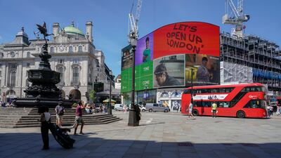 People walk in a quiet Piccadilly Circus, central London. The planned relaxation of coronavirus restrictions in England will be delayed as a result of the spread of the Delta variant first identified in India. AP