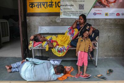 Woman on the street of India while man lays on ground, AFP
