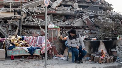HATAY, TURKEY - FEBRUARY 13: A man sits near a collapsed building as she waits news from her loved ones on February 13, 2023 in Hatay, Turkey. A 7.8-magnitude earthquake hit near Gaziantep, Turkey, in the early hours of Monday, followed by another 7.5-magnitude tremor just after midday. The quakes caused widespread destruction in southern Turkey and northern Syria and were felt in nearby countries. (Photo by Burak Kara / Getty Images)