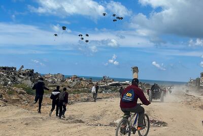 Palestinians rush towards the beach to collect aid airdropped by an airplane, on March 25. Reuters
