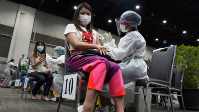 Health workers administer a dose of the AstraZeneca COVID-19 vaccine to women at Paragon shopping mall in Bangkok, Thailand, Monday, June 7, 2021. Health authorities in Thailand on Monday began their much-anticipated mass rollout of locally produced AstraZeneca vaccine, but it appeared that supplies were falling short of demand from patients who had scheduled vaccinations for this week. (AP Photo/Sakchai Lalit)