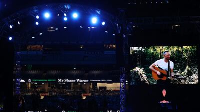 Chris Martin of Coldplay is seen in the big screen as he plays the guitar during the state memorial service for former Australian cricketer Shane Warne at the Melbourne Cricket Ground on March 30, 2022 in Melbourne, Australia. Getty Images