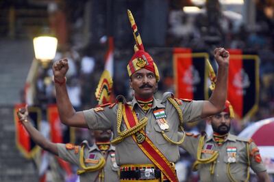 This picture taken on August 15, 2022, shows Indian Border Security Force (BSF) soldiers taking part in the Beating the Retreat ceremony during India's 75th Independence Day celebrations at the India-Pakistan Wagah border post, about 35km from Amritsar. (Photo by Narinder NANU / AFP)