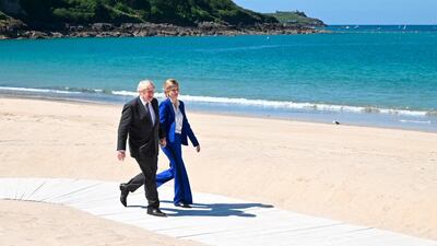 Britain's Prime Minister Boris Johnson and his wife Carrie Johnson make their way to greet guests at an official welcome at the G7 summit in Carbis Bay, Cornwall, England, on Saturday, June 12, 2021. AP