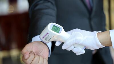 Dubai, United Arab Emirates - Reporter: N/A. News. Coronavirus/Covid-19. An employee takes a customers temperature at Cafe Society in Dubai. Wednesday, November 11th, 2020. Dubai. Chris Whiteoak / The National