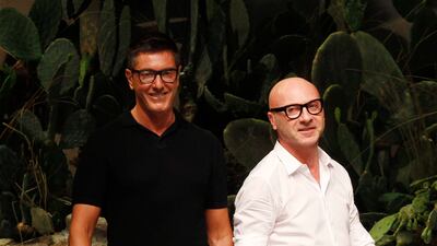 Italian fashion designers Stefano Gabbana, left, and Domenico Dolce take the catwalk after presenting their Dolce & Gabbana men's fashion collection in Milan, Italy. AP Photo