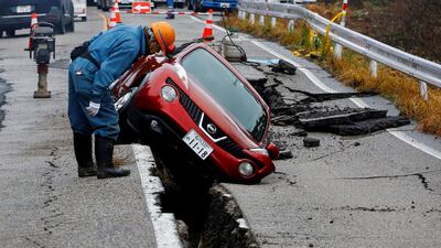 A worker looks at a car stuck on a broken road in the aftermath of an earthquake, near Anamizu, Japan, January 3, 2024. REUTERS / Kim Kyung-Hoon TPX IMAGES OF THE DAY