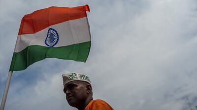 NEW DELHI, INDIA - AUGUST 15: A man taking part in India's Independence day celebrations, stands besides a India flag on August 15, 2022 in New Delhi, India. India celebrates its 75th Independence Day on Monday. (Photo by Anindito Mukherjee / Getty Images)